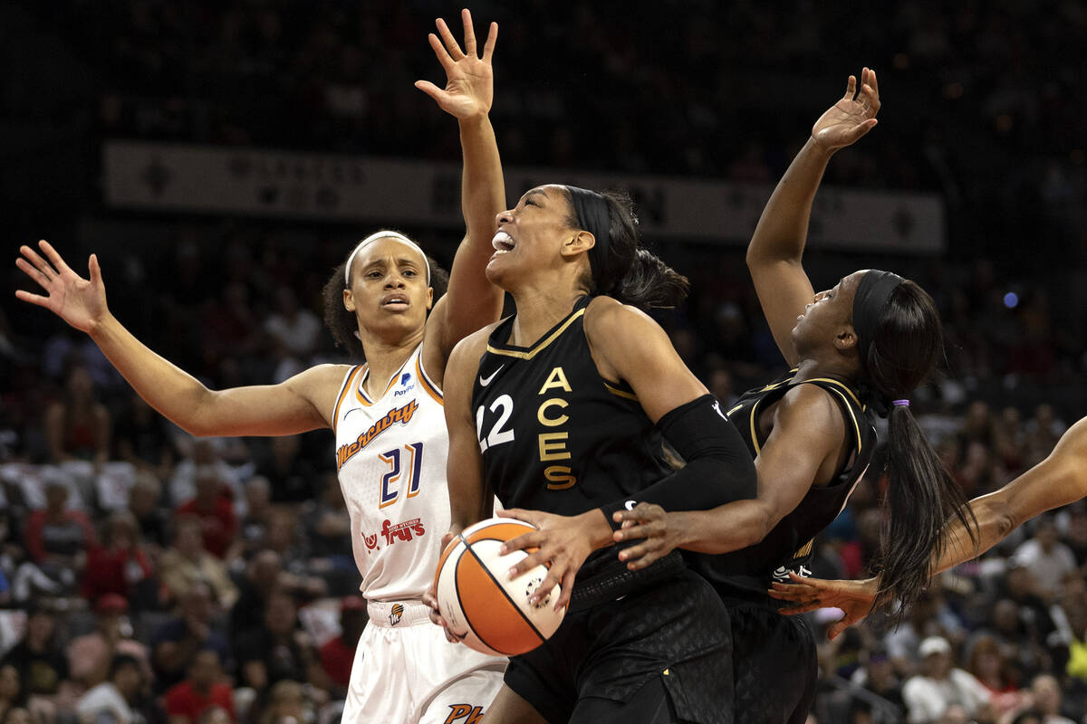 Las Vegas Aces forward A'ja Wilson (22) pushes past guard Jackie Young (0) to shoot against Pho ...