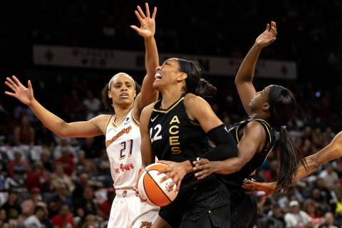 Las Vegas Aces forward A'ja Wilson (22) pushes past guard Jackie Young (0) to shoot against Pho ...