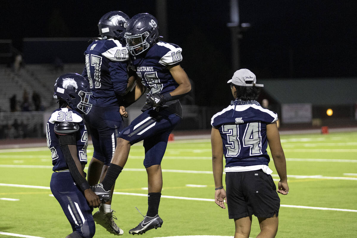Shadow Ridge tight end Enius Young (17) bumps chests with wide receiver Devon Poloa (19) after ...