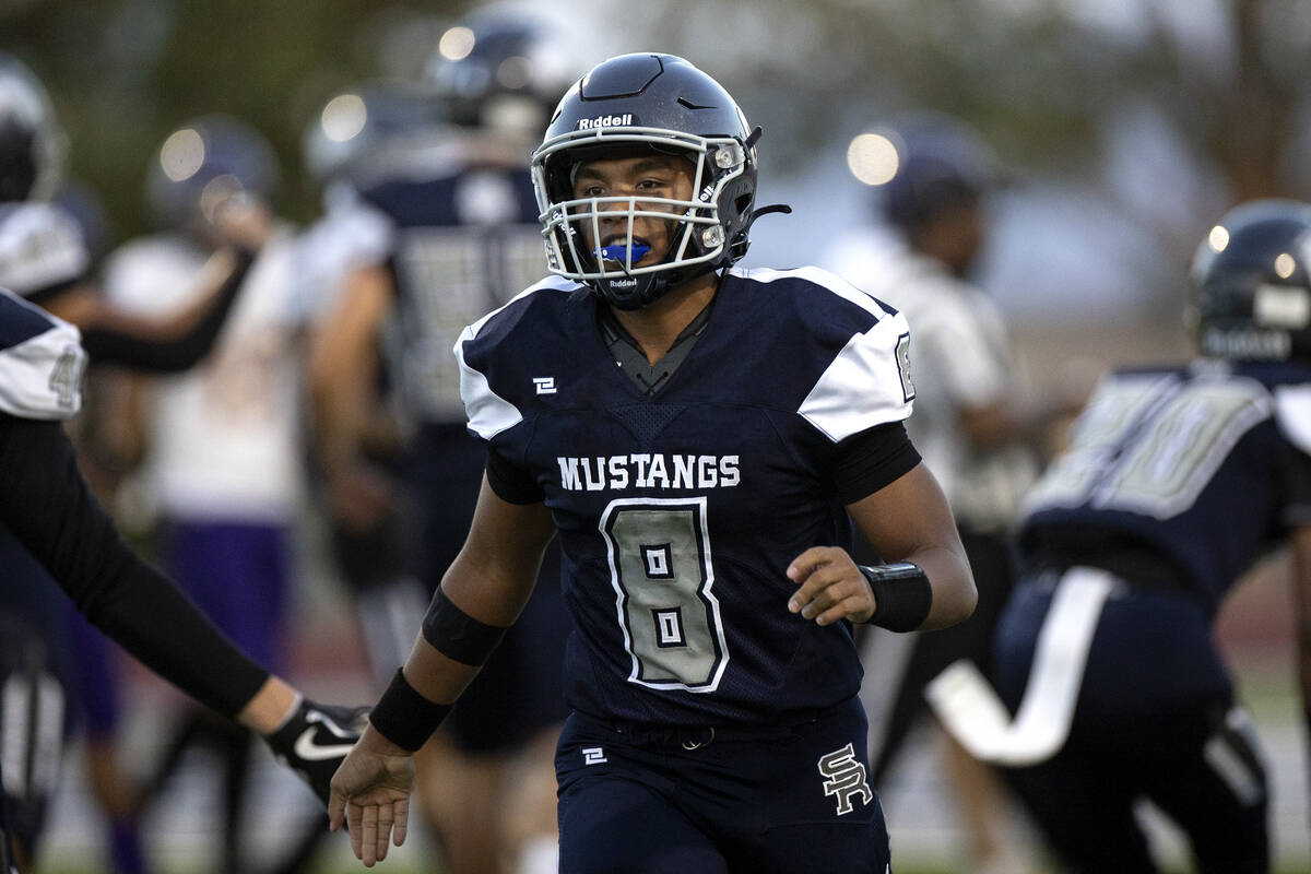 Shadow Ridge quarterback Coen Coloma (8) slaps hands with teammates after scoring a touchdown d ...