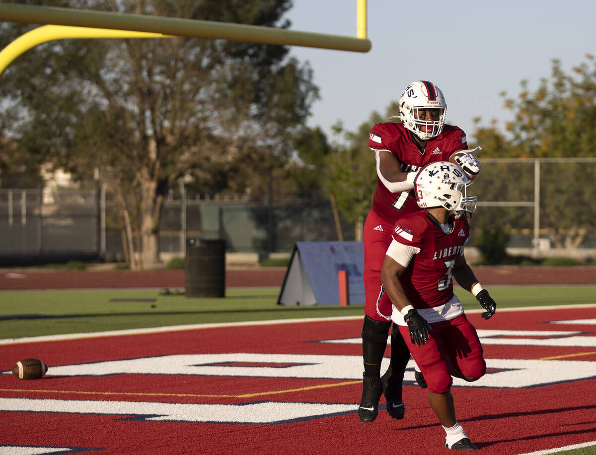 Liberty wide receiver Colin Gregorio (17) celebrates with running back Isaiah Lauofo (3) after ...