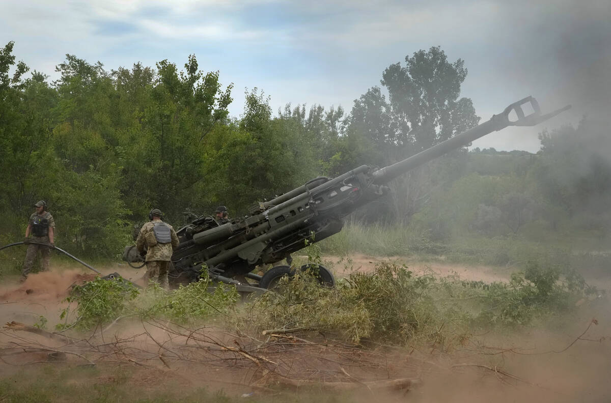 FILE - Ukrainian soldiers fire at Russian positions from a U.S.-supplied M777 howitzer in Ukrai ...