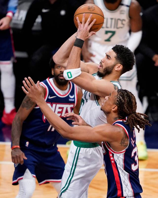 Boston Celtics forward Jayson Tatum (0) shoots against Brooklyn Nets forward Nic Claxton, right ...