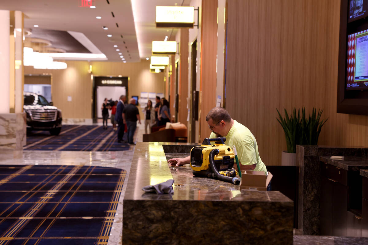 Workers put the finishing touches on the registration desk and pre-function area at the new mee ...