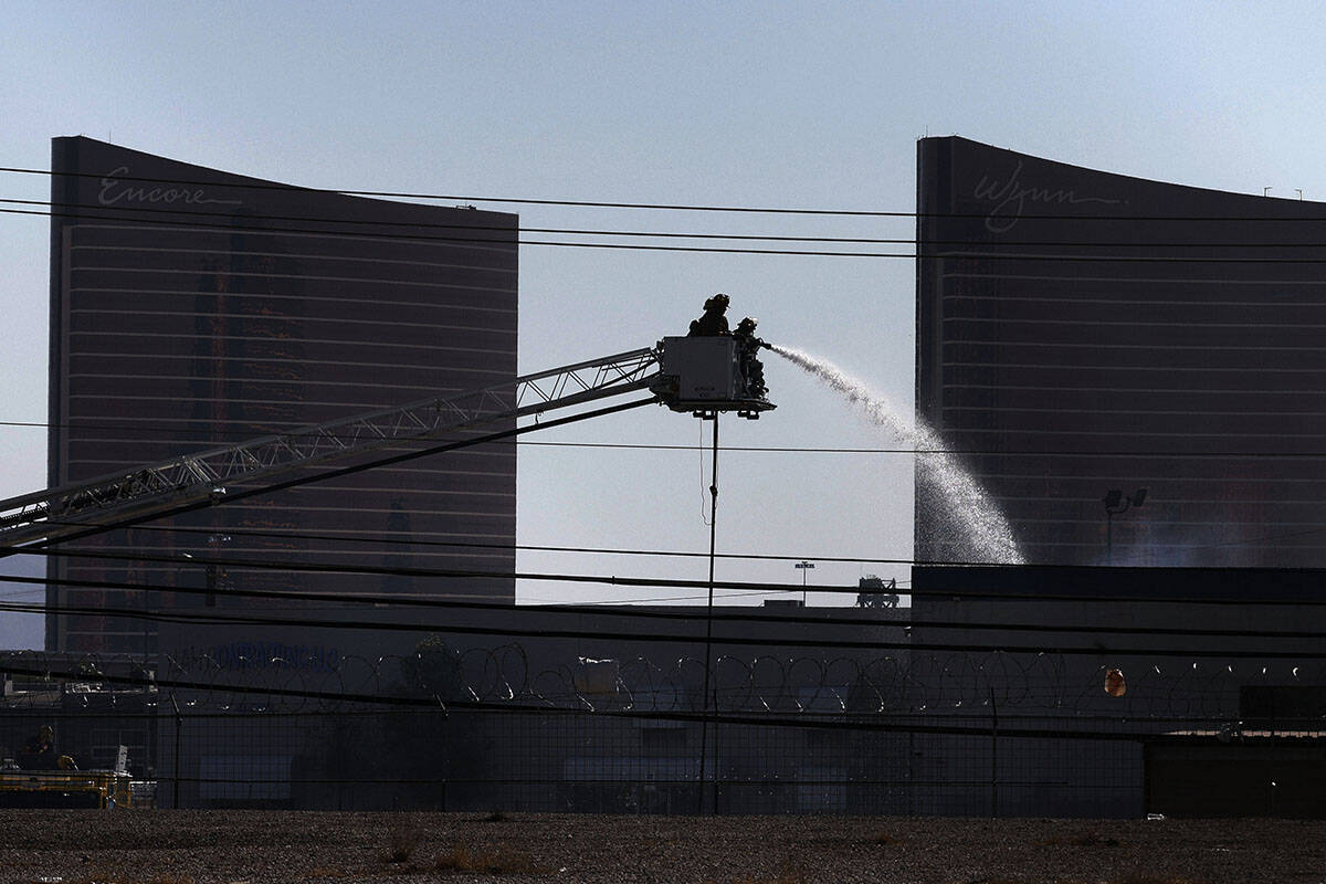 Firefighters try to extinguish a fire near Procyon Street, Tuesday, Aug. 23, 2022, in Las Vegas ...