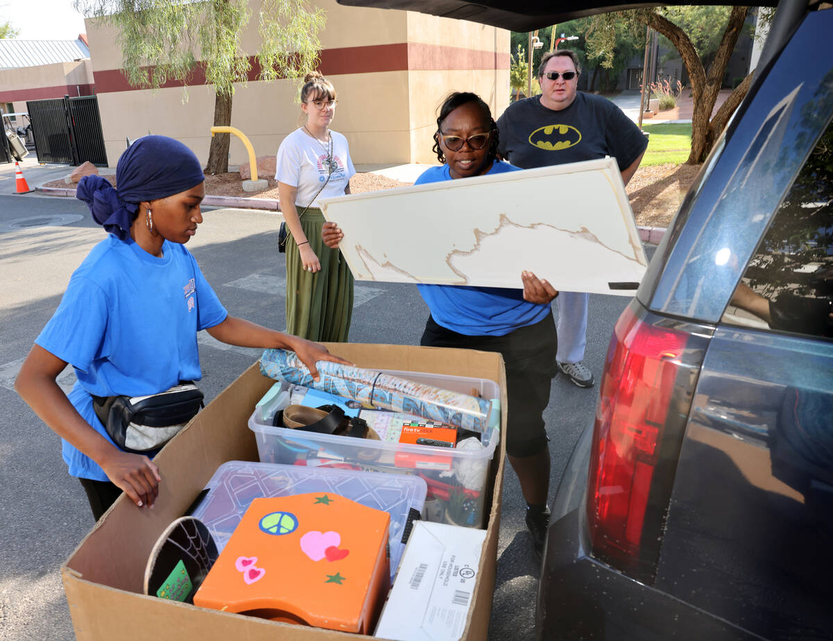 Student Holly Rutt, of Denver, watches as movers Kieishia McNeal, left, and Melo McCall load he ...