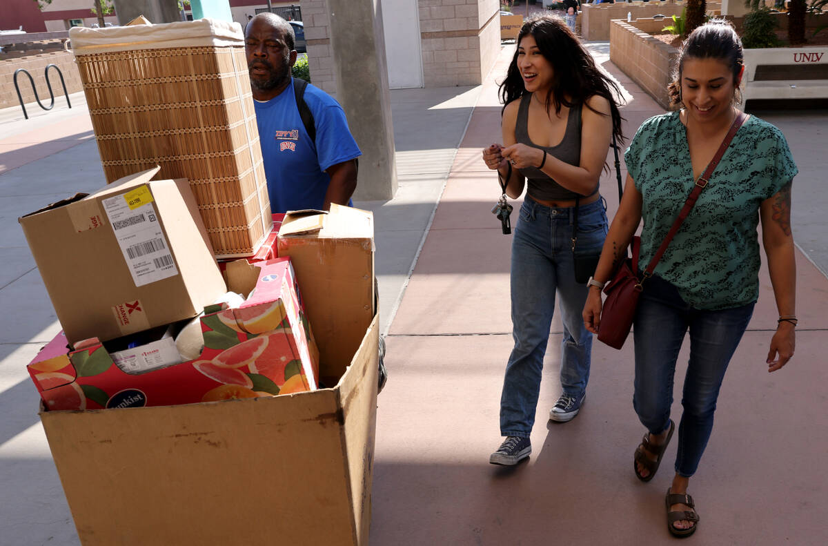 Samara Casias and her mother Shayla watch as Thomas Aultman loads her possessions during dorm m ...