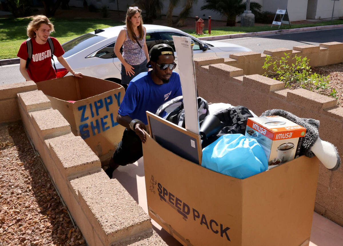 Sky Denson, of Galveston, Texas, and mover Johnny Carlisle load his possessions during dorm mov ...