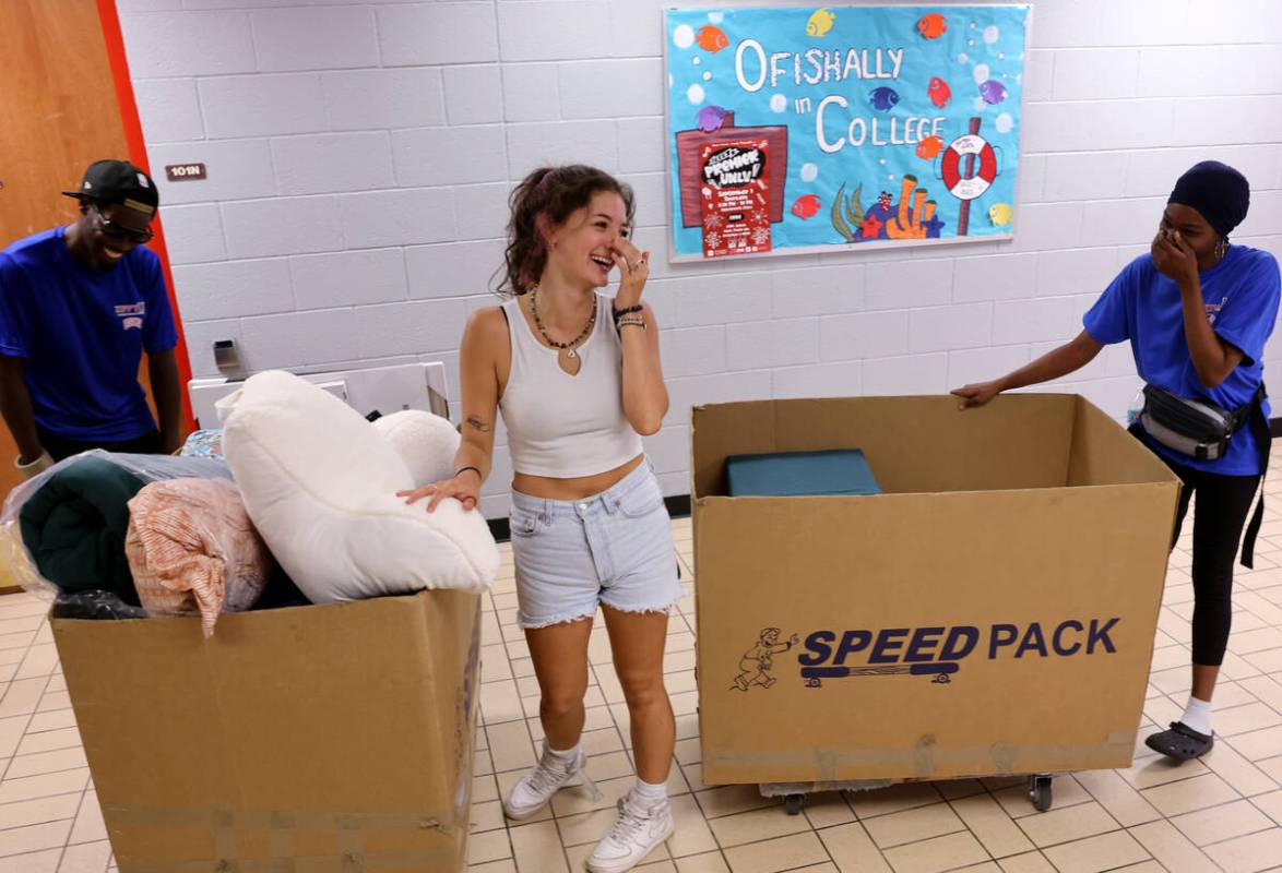 Student Viviana Dolfin shares a laugh with movers, Johnny Carlisle, left, and Kieishia McNeal d ...