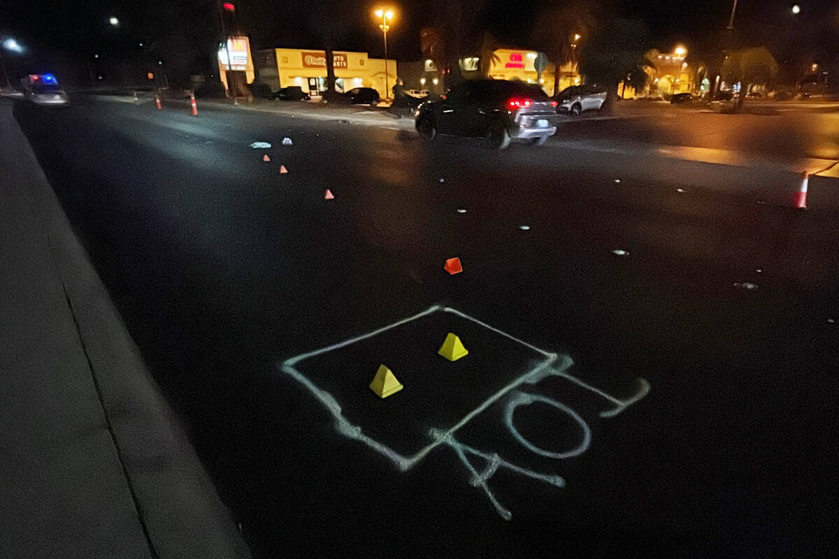 The area where a pedestrian was hit by a car is marked with yellow cones and spray paint near t ...