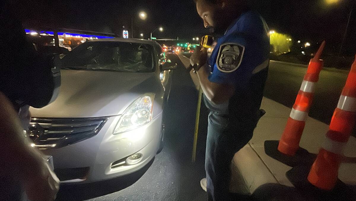 Officer Andy Navarro inspects the damage to a Nissan Altima after it struck a pedestrian outsid ...