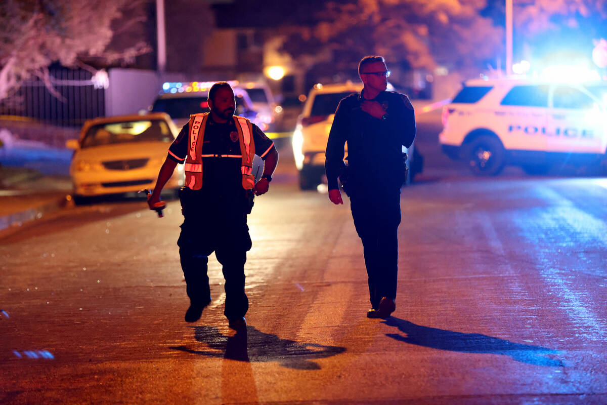 North Las Vegas Police Officer Andy Navarro, left, investigates a hit-and-run crash on North Ma ...