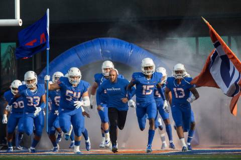 Bishop Gorman head coach Kenny Sanchez, middle, leads the Gaels onto the field before the start ...