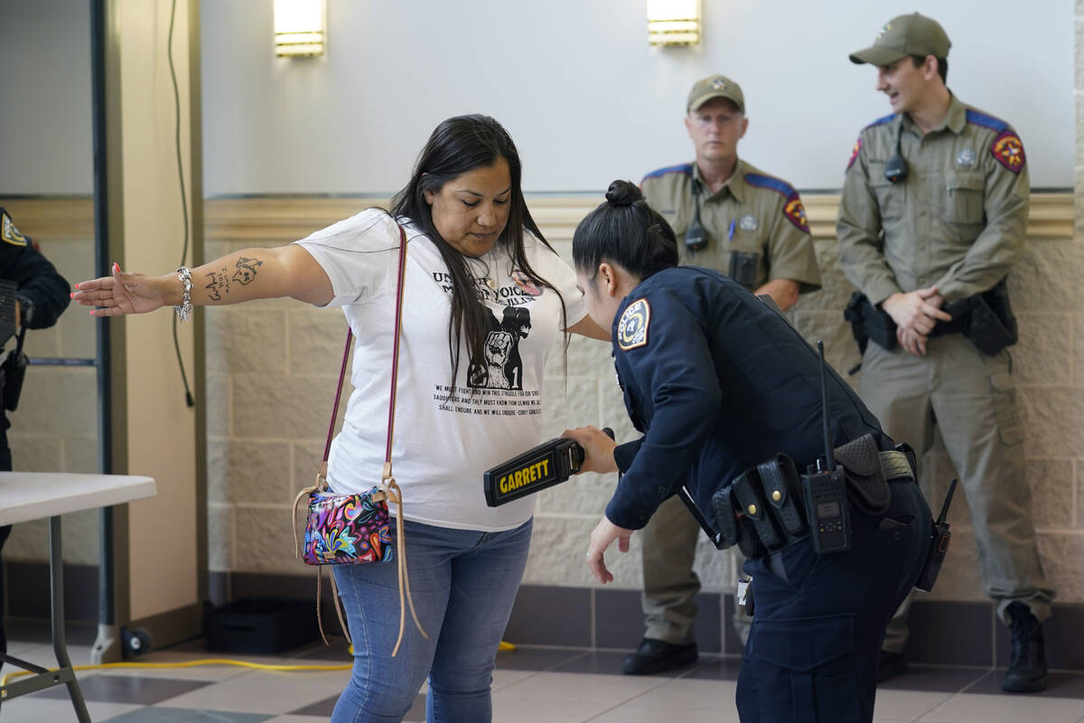 Parents, students and families go through security as they arrive for a meeting of the Board of ...