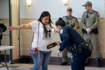 Parents, students and families go through security as they arrive for a meeting of the Board of ...