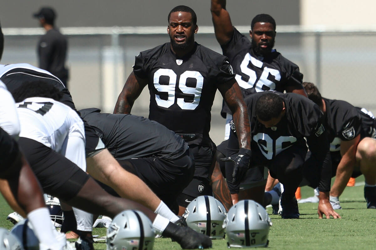 Raiders defensive ends Clelin Ferrell (99) and Gerri Green (56) stretch during practice at Raid ...