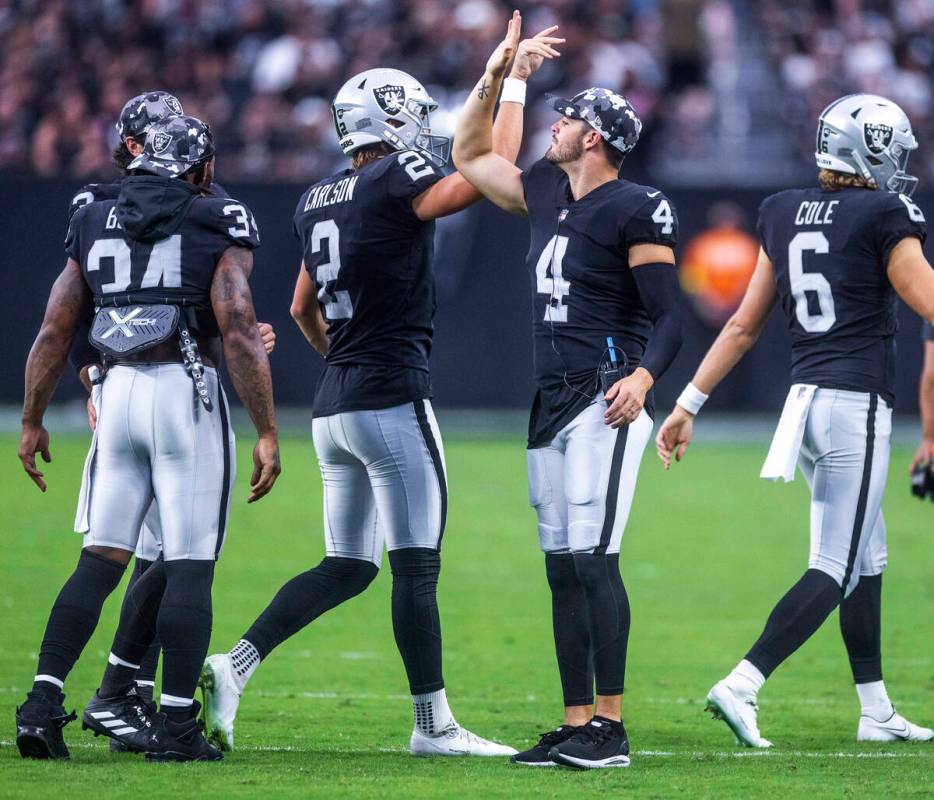 Raiders quarterback Derek Carr (4) congratulates place kicker Daniel Carlson (2) on another sco ...