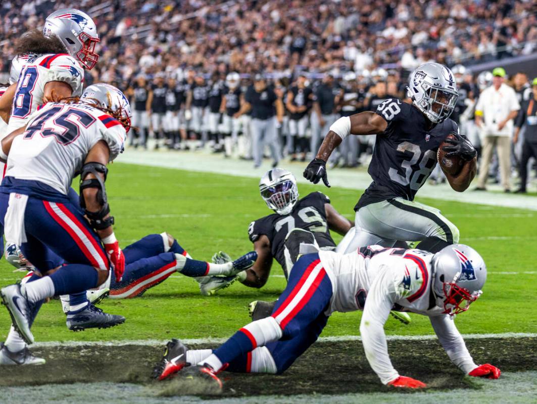 Raiders running back Brittain Brown (38) scampers into the end zone as New England Patriots saf ...
