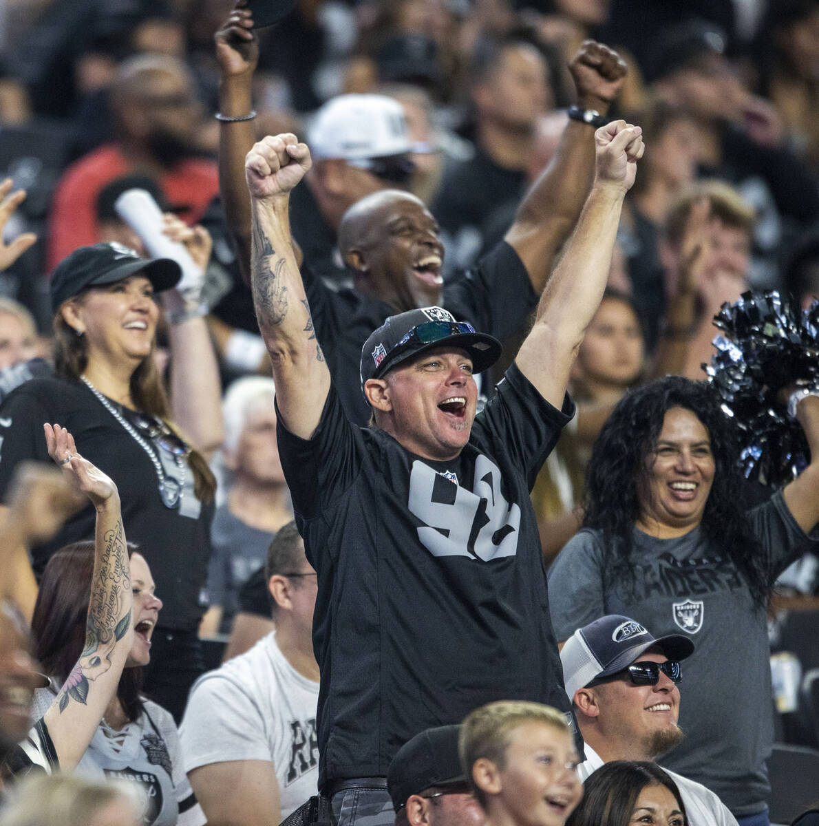 A Raiders fan cheers during the second half of an NFL game against the New England Patriots at ...