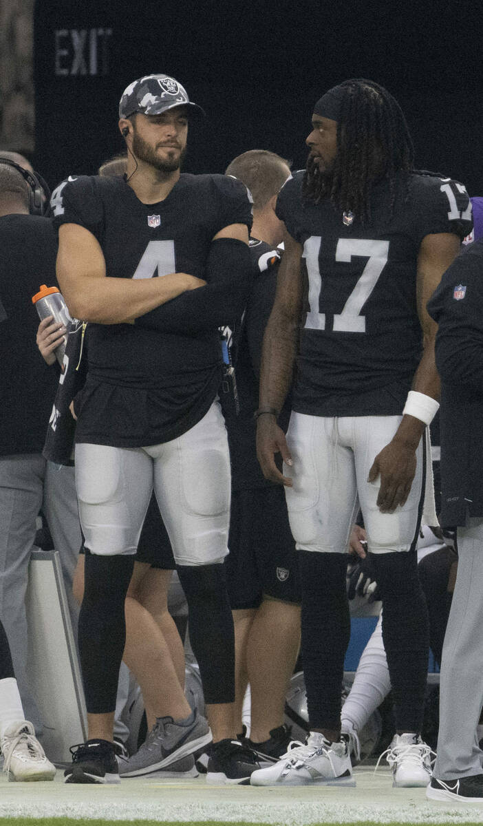 Raiders quarterback Derek Carr (4) and Raiders wide receiver Davante Adams (17) engage in conve ...