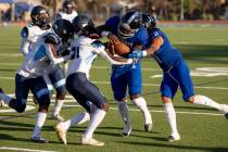 Desert Pines junior Marquis Roby (1) tries to break through the Canyon Springs defense in the f ...