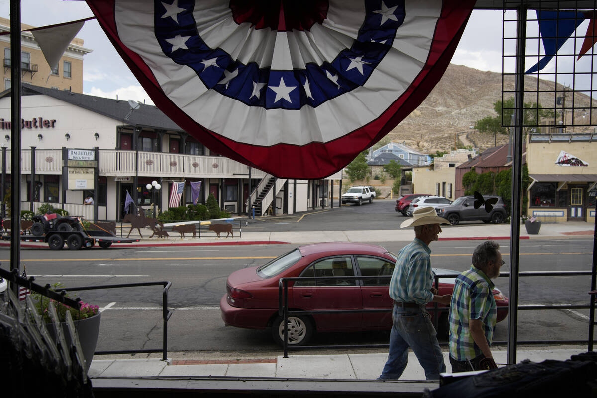 FILE - People walk along the main drag in the county seat of Nye county, Monday, July 18, 2022, ...