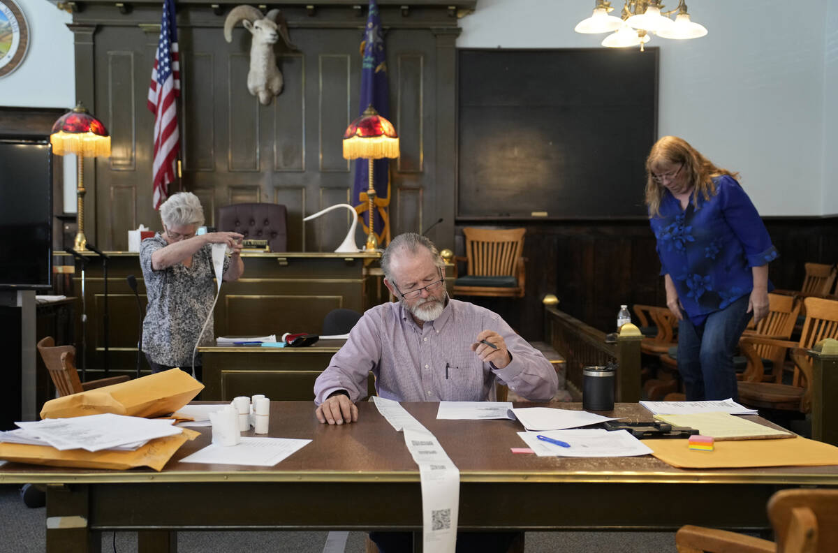 FILE - Esmeralda County Commissioner Ralph Keyes, center, works on a hand recount of votes with ...