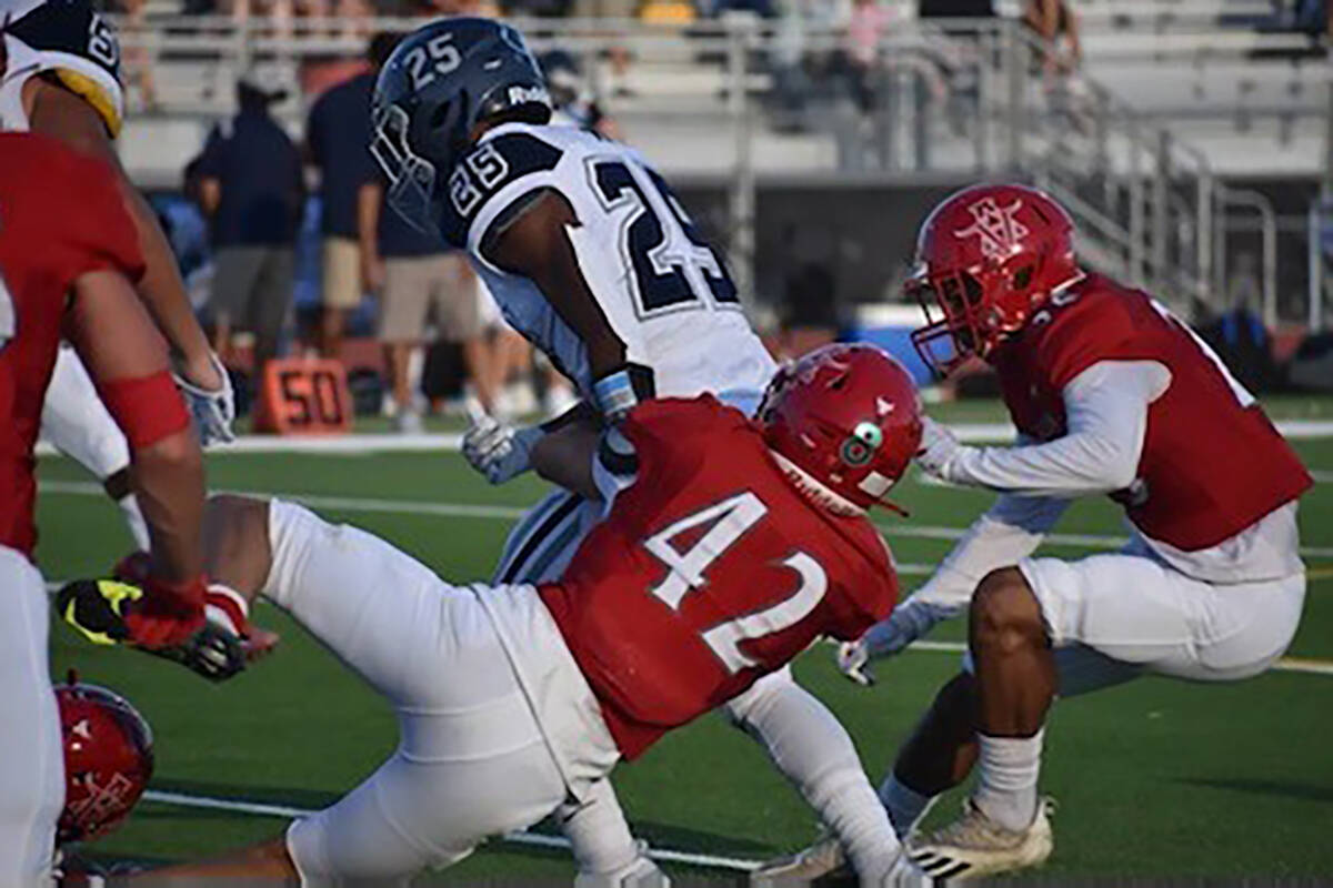 Arbor View linebacker Christian Thatcher wraps up Shadow Ridge running back JaQuieze Holland du ...