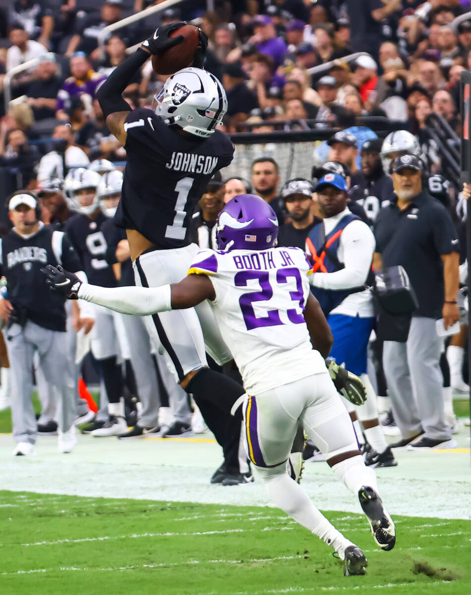 Raiders wide receiver Tyron Johnson (1) goes up for the reception under pressure from Minnesota ...