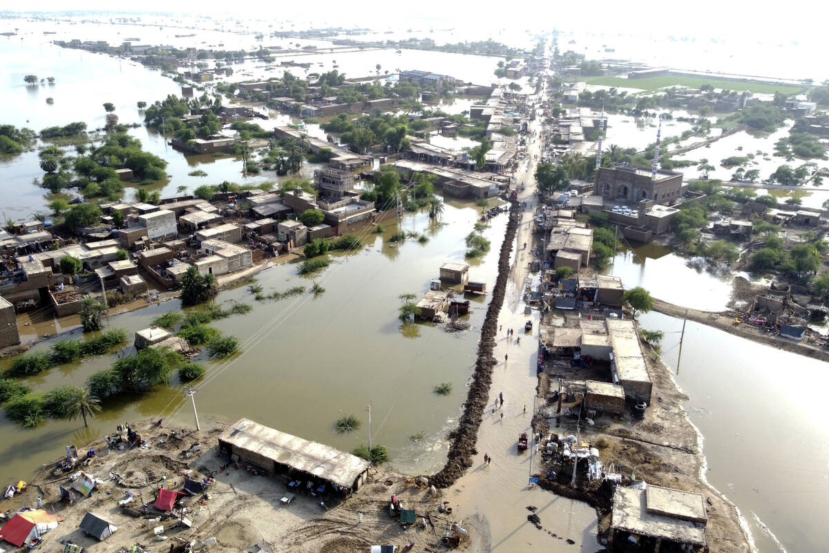 FILE - Homes are surrounded by floodwaters in Sohbat Pur city of Jaffarabad, a district of Paki ...