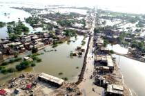 FILE - Homes are surrounded by floodwaters in Sohbat Pur city of Jaffarabad, a district of Paki ...