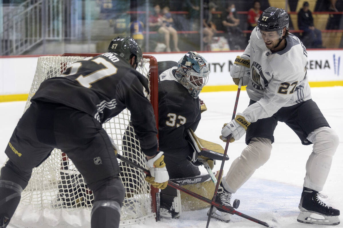 Golden Knights defenseman Shea Theodore (27) takes a shot on goaltender Adin Hill (33) while fo ...