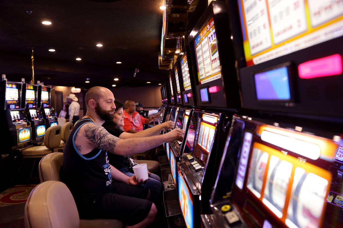 Audra Robison and her husband Neil, of Salt Lake City, play coin slot machines at Circus Circus ...