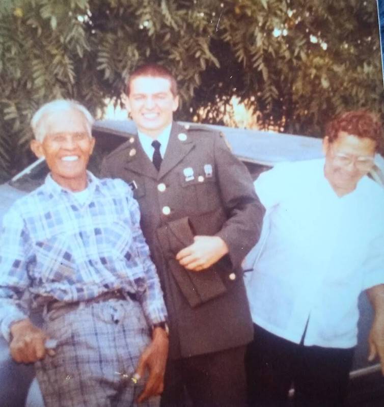 A photo of Stewart Rhodes surprising his grandparents in the farm fields they were working in t ...