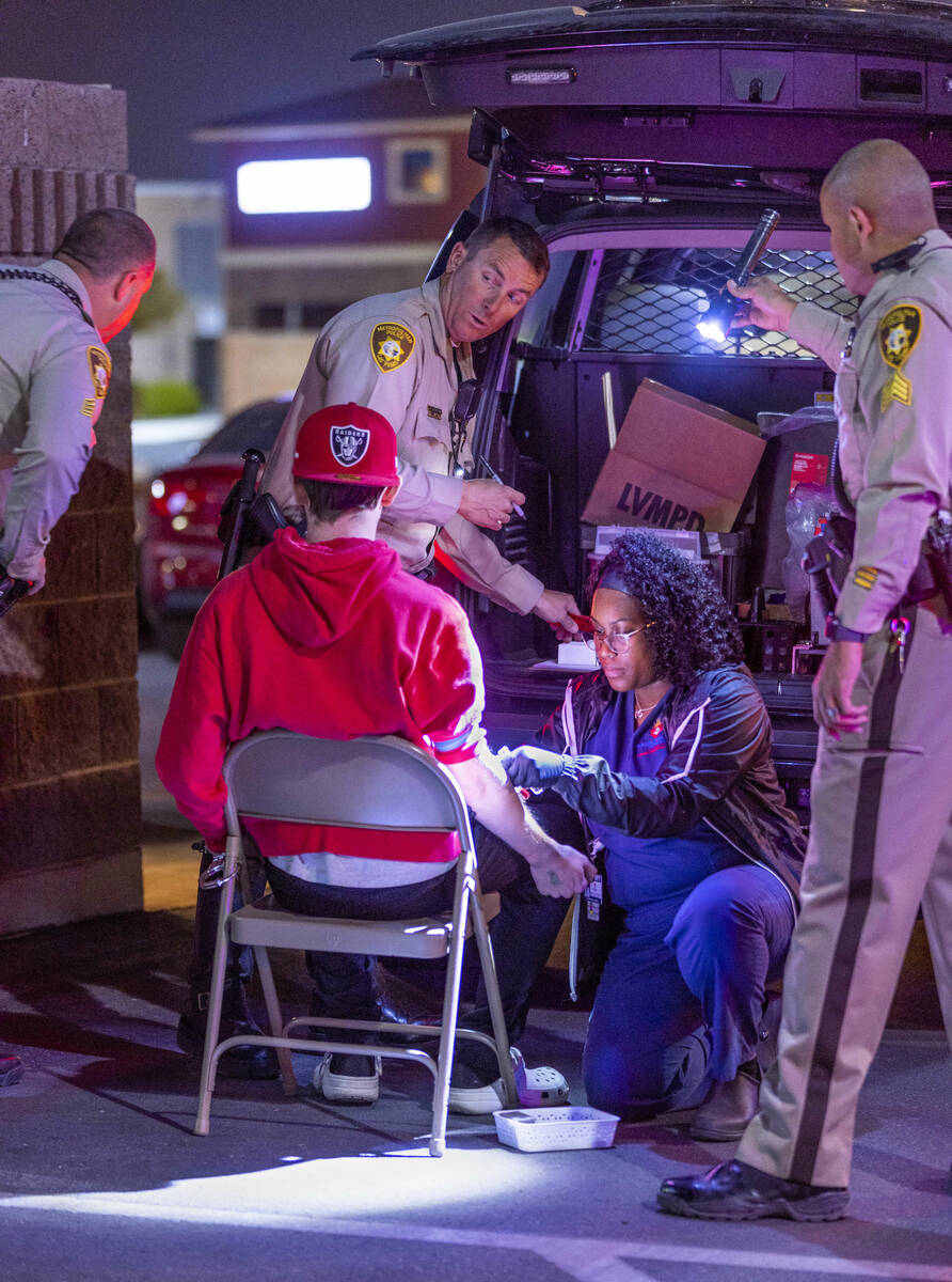 Ashley Webber-Gamboa with Sunrise Pathology Services, bottom right, draws blood on a suspected ...