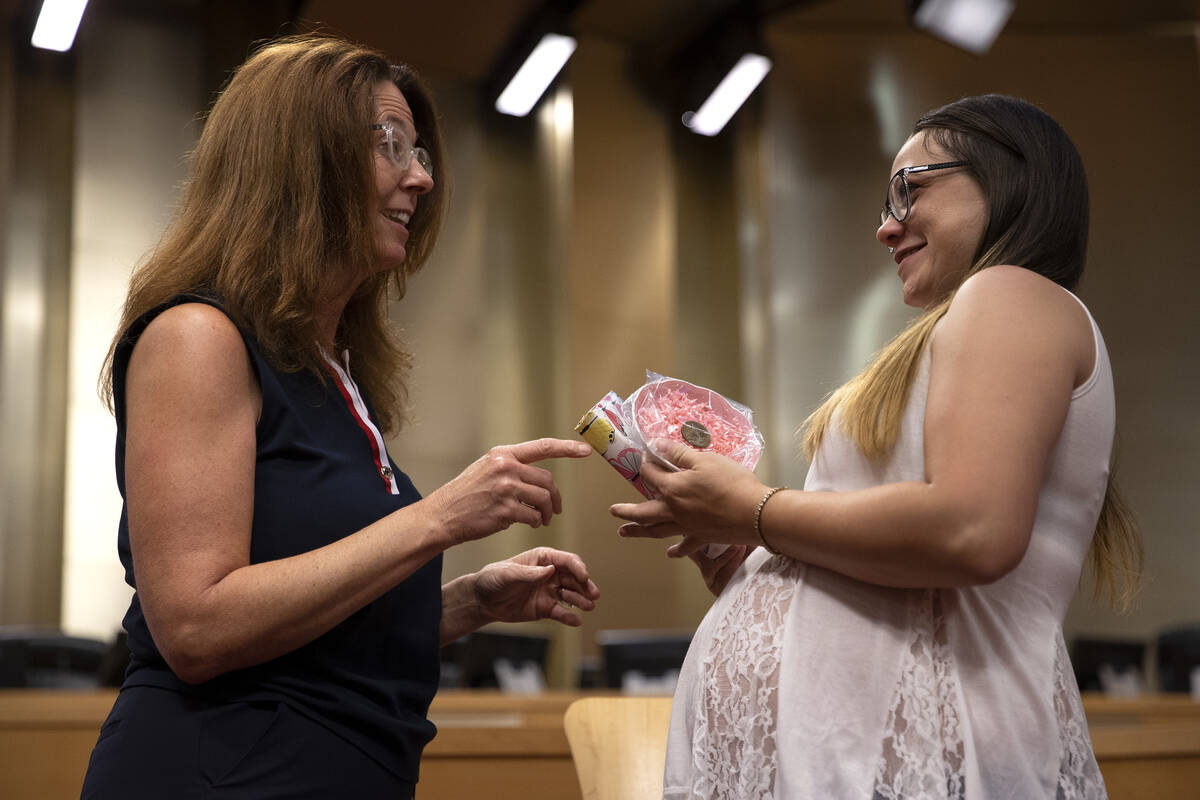 Social worker Stefanie Maplethorpe presents Bridget Stevens with a gift during a WIN Court grad ...