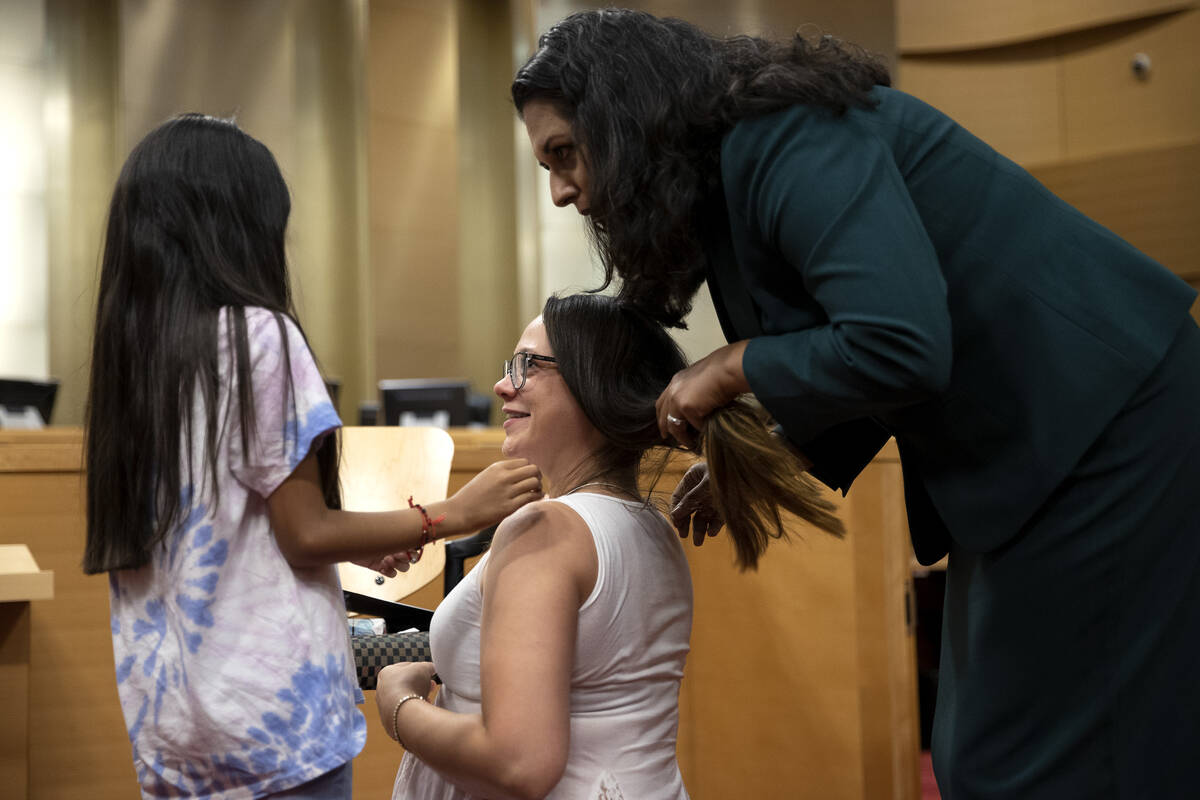 Councilwoman Olivia Diaz and Aaliyah Hernandez, 8, Bridget Steven’s daughter, put a neck ...