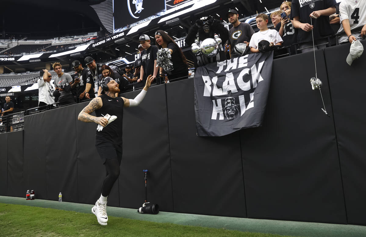 Raiders defensive end Maxx Crosby high-fives fans before the start an NFL preseason football ga ...