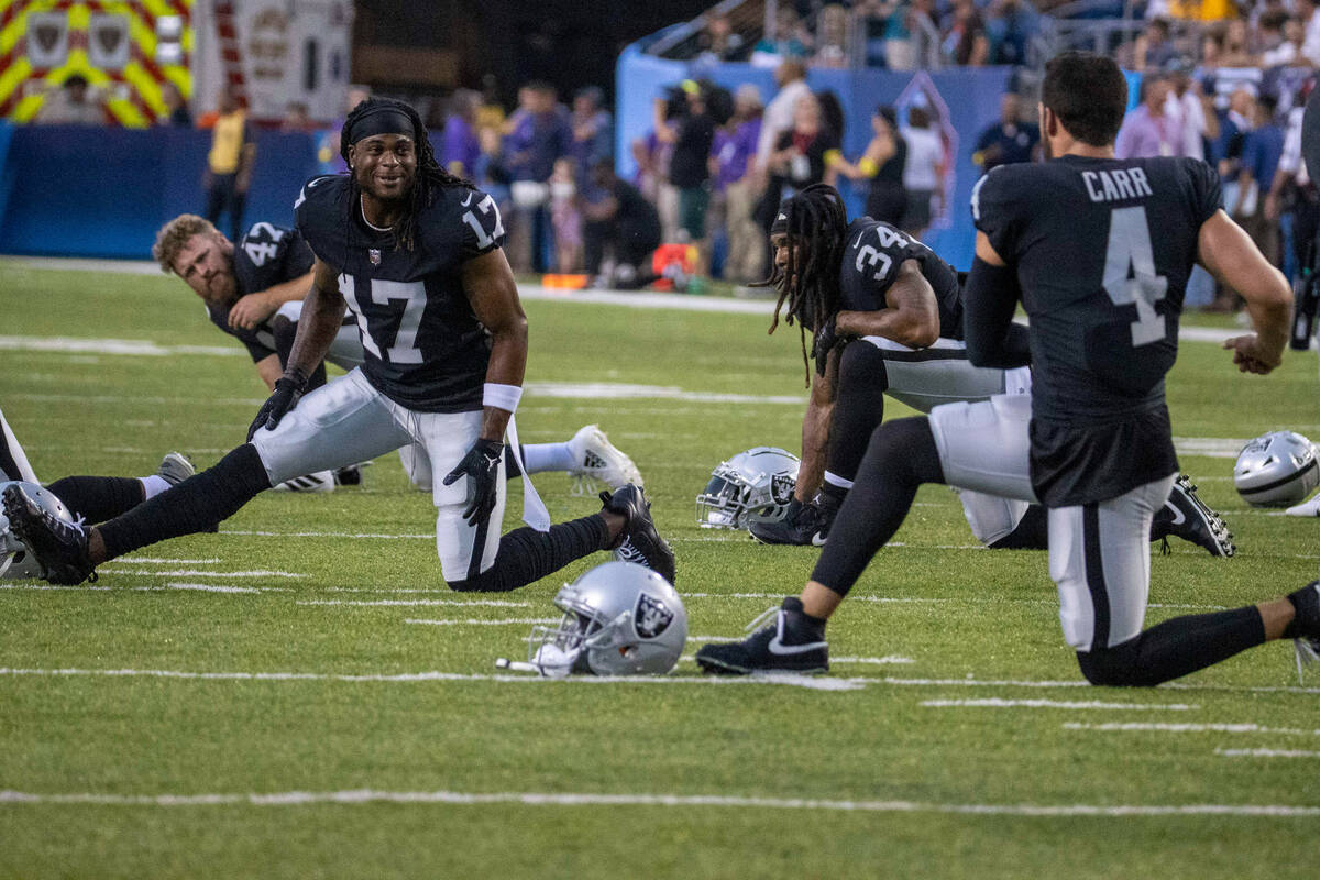 Raiders wide receiver Davante Adams (17) and Raiders quarterback Derek Carr (4) engage as they ...