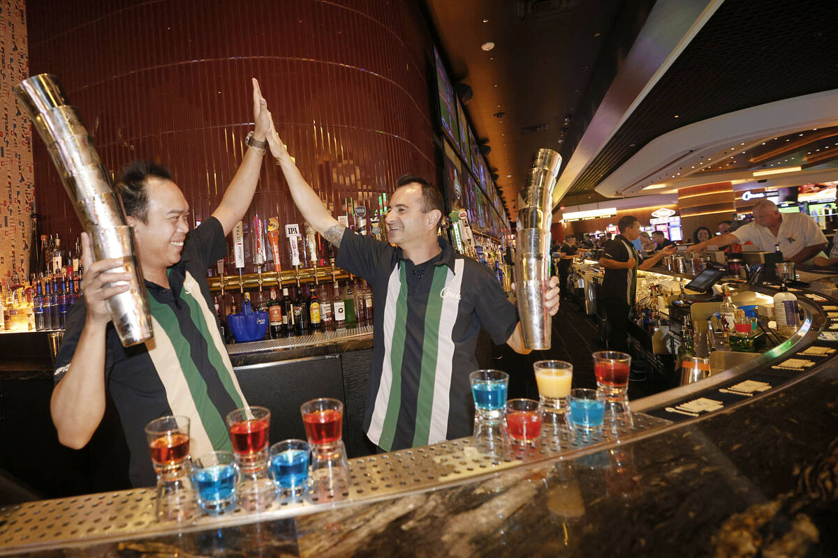 Flair bartenders Spyder Rigor, left, and Vache Manoukian high-five after a demonstration of the ...