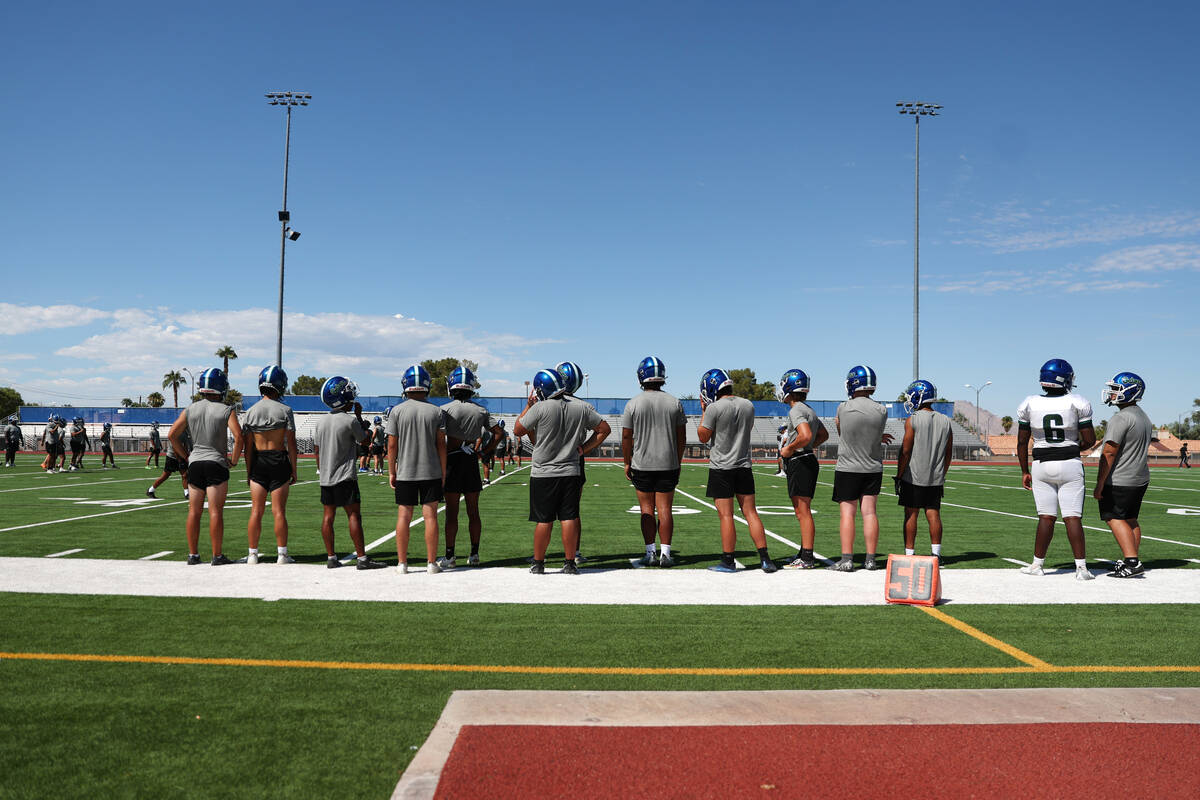 Players stand on the sideline during a football practice at Green Valley High School in Henders ...