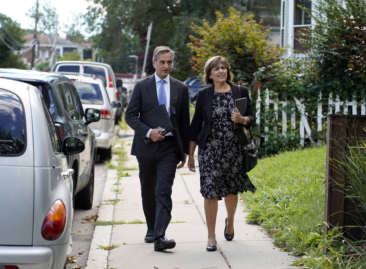 Dan Sideris and his wife, Carrie Sideris, of Newton, Mass., walk along a sidewalk as they retur ...