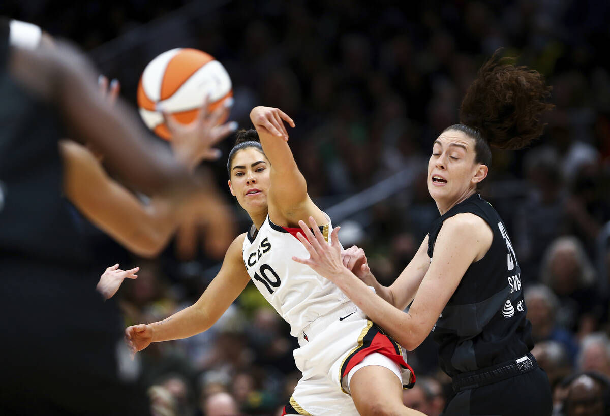 Las Vegas Aces guard Kelsey Plum (10) passes around Seattle Storm forward Breanna Stewart durin ...