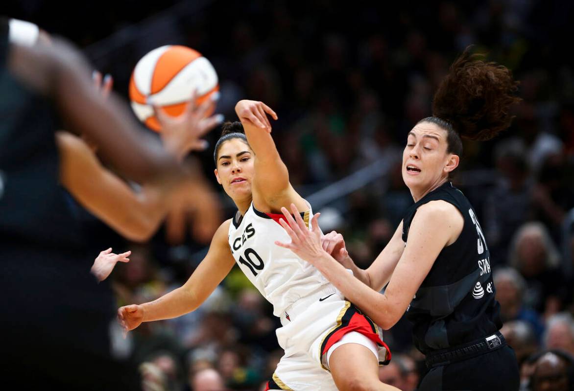 Las Vegas Aces guard Kelsey Plum (10) passes around Seattle Storm forward Breanna Stewart durin ...