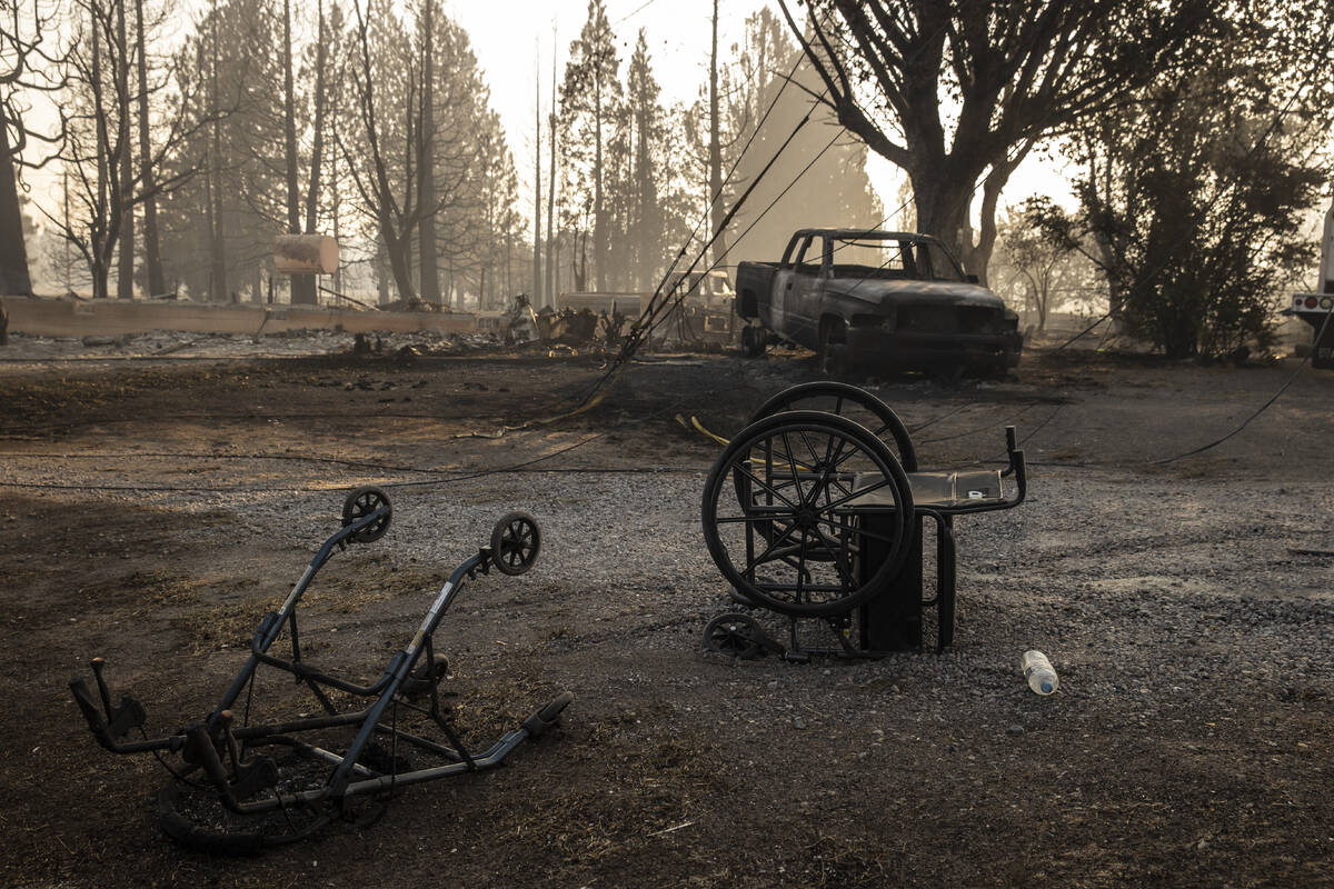 An overturned walker and wheelchair are seen near a home destroyed by the Mill Fire in Weed, Ca ...