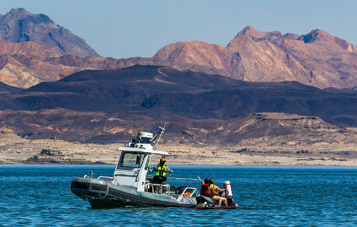 Law enforcement counsels jet skiers who have entered a no wake zone at high speed off of Boulde ...