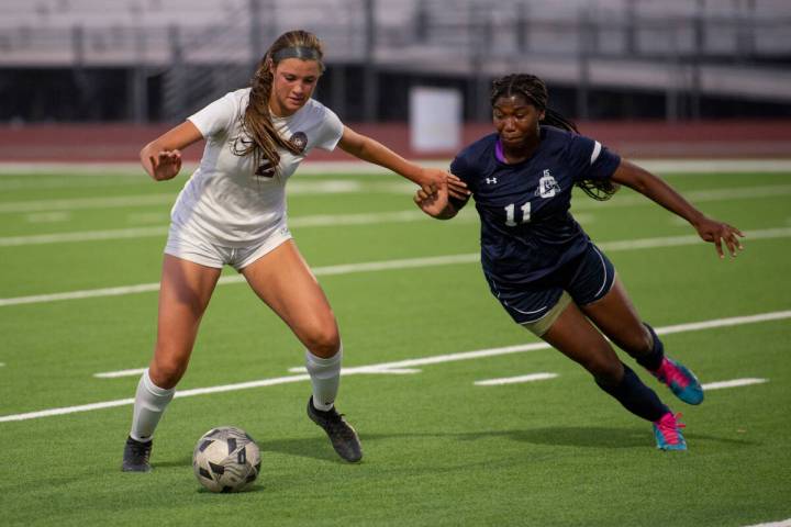 Desert Oasis senior Kate Perkes (2) tries to keep the ball from Centennial High School sophomor ...