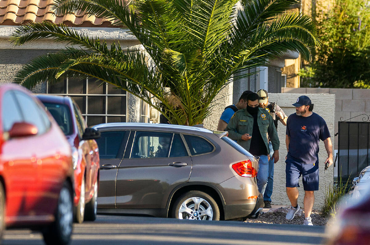 Metro Officers depart the home of Robert Telles along the 9600 block of West Spanish Steps Lane ...