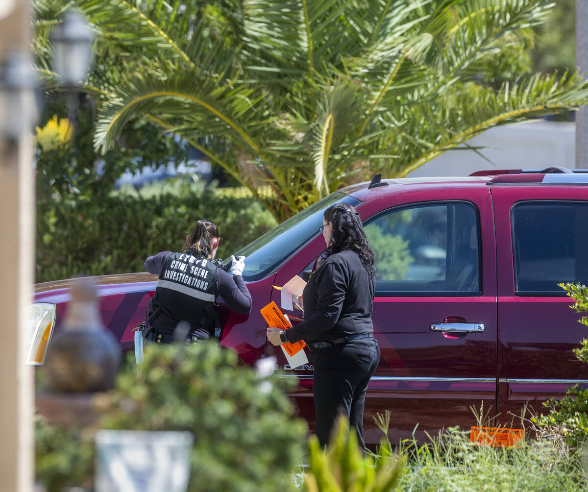 Metro Crime Scene Investigators put on a "warning keep out" sticker along hood of a s ...