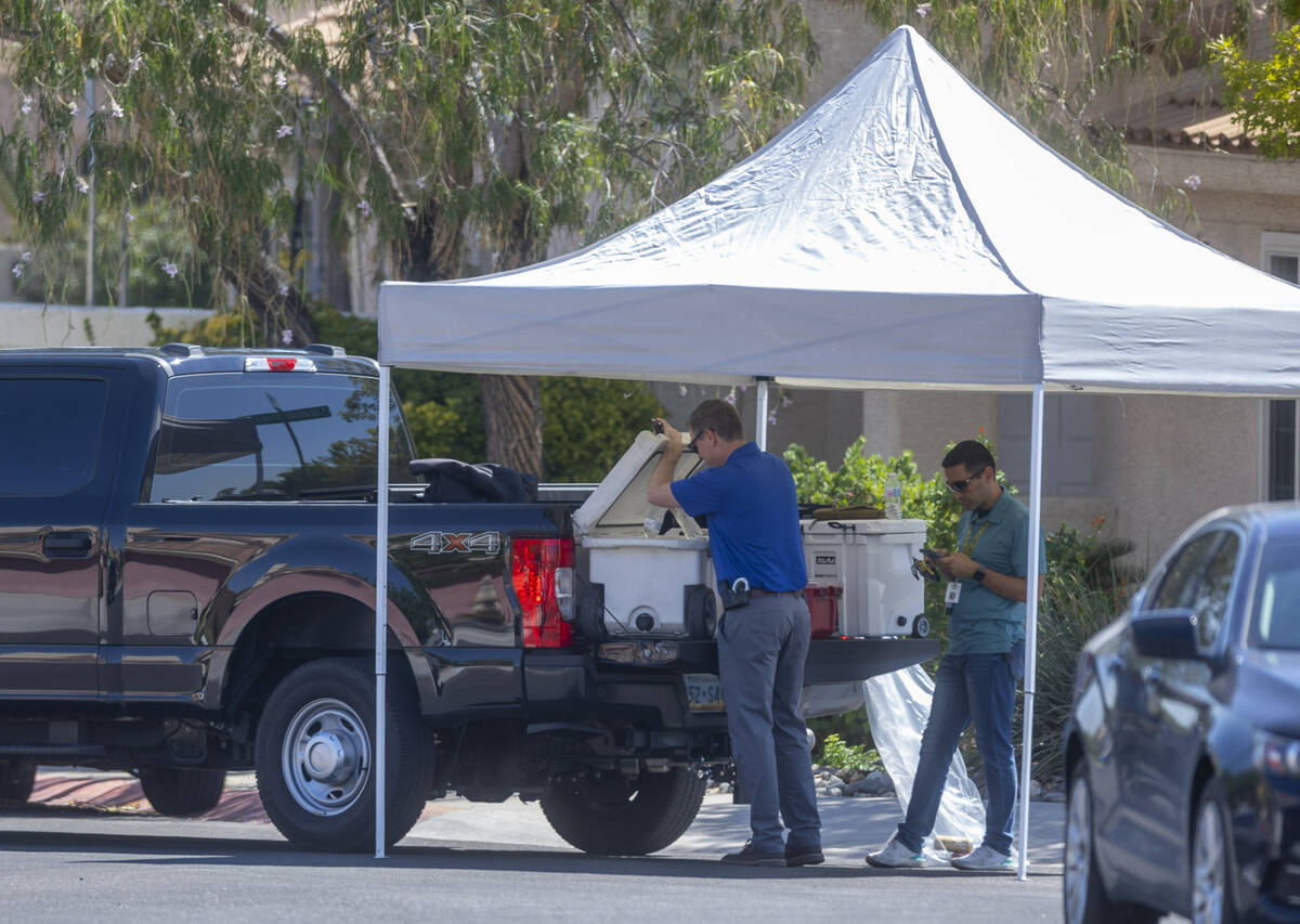 Metro Homicide Detectives work beneath a tent in the street outside the home of Robert Telles a ...